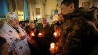Ada juga yang merayakannya di sebuah gereja. Tampak seorang pendeta Gereja Ortodoks Ukraina berbicara dengan prajurit Ukraina setelah kebaktian Natal, di tengah serangan Rusia terhadap Ukraina, di Gereja St. John Theologian di Kharkiv, Ukraina 25 Desember 2022.