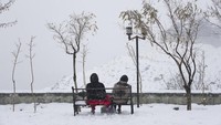 Dua warga Teheran menikmati suasana kawasan rekreasi dan olah raga di utara kota Teheran, Iran, Sabtu (24/12/2022).  
