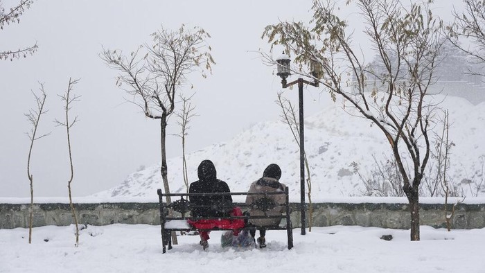 Musim Salju Redakan Kekeringan Berkepanjangan di Iran People enjoy their time as snow falls at mountainous Tochal Sport and Recreational Complex in northern Tehran, Iran, Saturday, Dec. 24, 2022. The snow and rain brought happiness to many people who were worried about lack of water in Iran, the country which has suffered decades-long drought. In recent weeks authorities have frequently warned about decreasing level of water behind dams across the country especially around the capital Tehran. (AP Photo/Vahid Salemi)