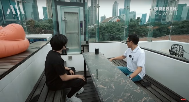 Di sebelah kolam renangnya terdapat bangku dan meja kecil untuk duduk-duduk. Uniknya lagi di dekat kolam dan bangku tersebut terdapat lift kecil khusus makanan. Foto: YouTube/AH