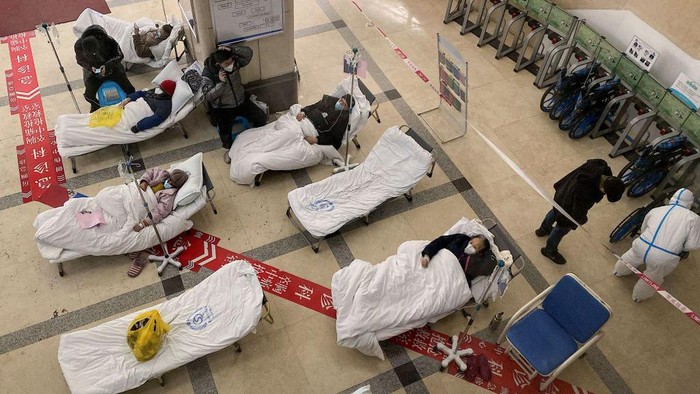 TOPSHOT - Covid-19 coronavirus patients lie on hospital beds in the lobby of the Chongqing No. 5 People's Hospital in China's southwestern city of Chongqing on December 23, 2022. (Photo by Noel CELIS / AFP) (Photo by NOEL CELIS/AFP via Getty Images)