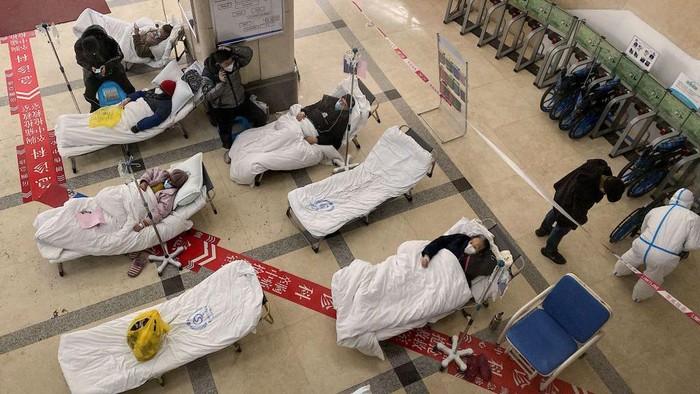 Saat Pasien COVID-19 Melonjak, Rumah Sakit di China Kewalahan TOPSHOT - Covid-19 coronavirus patients lie on hospital beds in the lobby of the Chongqing No. 5 People's Hospital in China's southwestern city of Chongqing on December 23, 2022. (Photo by Noel CELIS / AFP) (Photo by NOEL CELIS/AFP via Getty Images)
