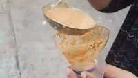 Tak punya corong, penjual kue ini tak kehabisan akal. Memotong bagian leher botol minum, dirinya berhasil membungkus sambal kacang tanpa tumpah. Foto: Instagram/uncoditionaldesign
