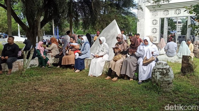 Warga berziarah di kuburan massal Siron. (Agus Setyadi/detikSumut)