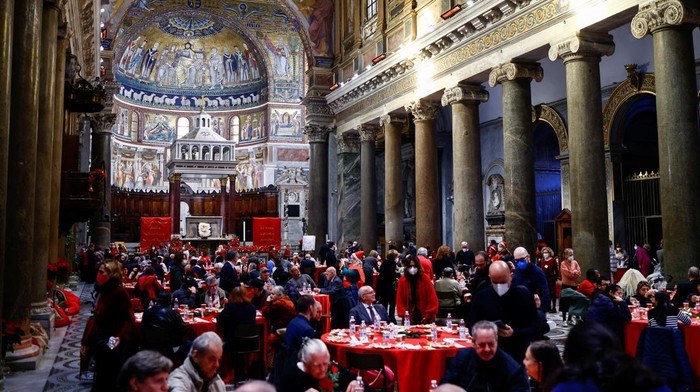 Warga Italia Rayakan Natal dengan Makan Siang Bersama Tunawisma People sit inside the Basilica of Santa Maria in Trastevere as they eat during the traditional Christmas lunch for the needy and poor, in Rome, Italy, December 25, 2022. REUTERS/Yara Nardi
