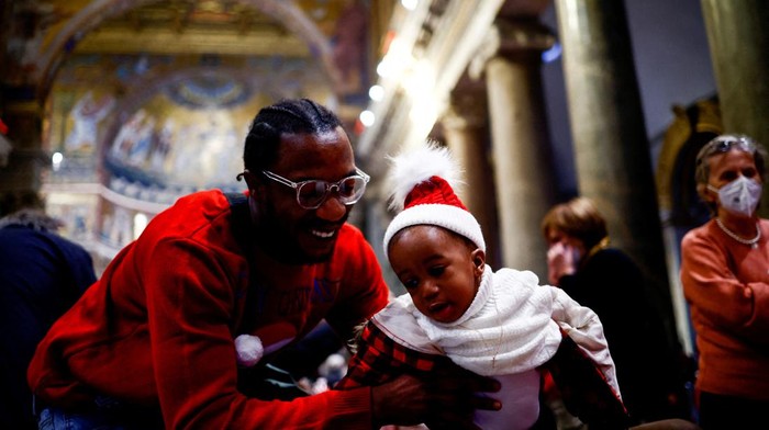 People sit inside the Basilica of Santa Maria in Trastevere as they eat during the traditional Christmas lunch for the needy and poor, in Rome, Italy, December 25, 2022. REUTERS/Yara Nardi