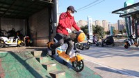 Seorang karyawan mengeluarkan sepeda listrik dari truk di Lianyungang, Jiangsu, China.