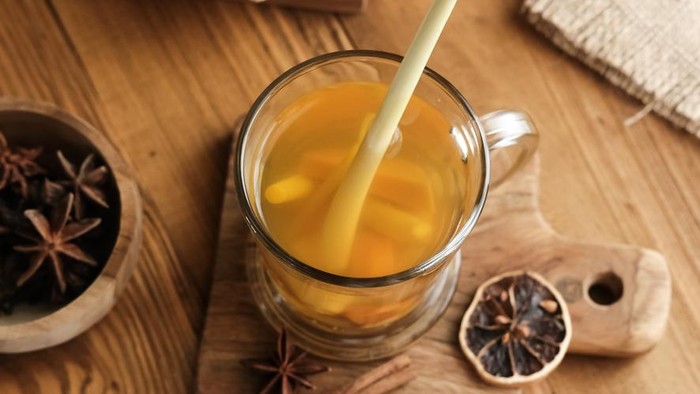 Empon-empon, Rimpang or Jamu, Indonesian traditional herbal drink, made from ginger, turmeric, and other herbs. Served in glass on wooden table, selective image and blurred background.