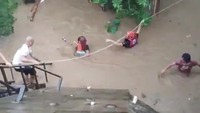 Foto-foto yang dirilis oleh penjaga pantai menunjukkan para petugas penyelamat berpakaian oranye menggendong anak-anak kecil yang diambil dari rumah-rumah yang terendam banjir setinggi pinggang orang dewasa. Reuters/Philippine Red Cross  