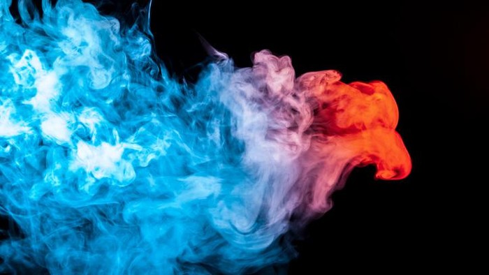 A multi-colored pattern of blue smoke of a mystical shape in the form of a face and a ghosts head or a strange creature on a black isolated background. Abstract pattern in of waves and steam
