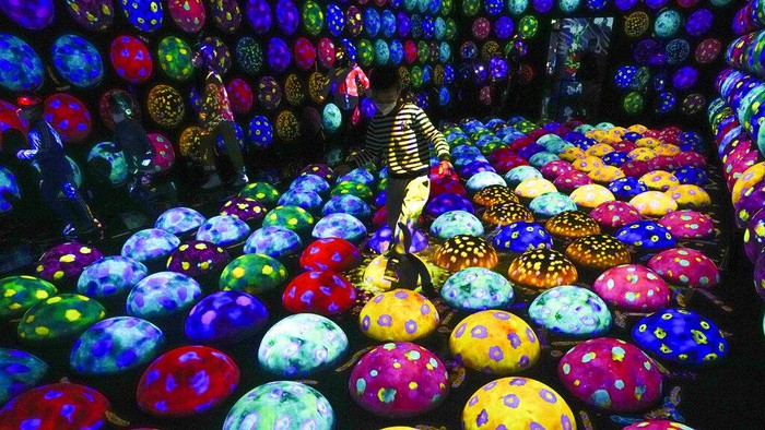 Family members experience a digital installation that features projection of flowers titled 