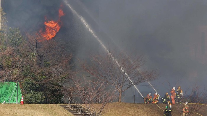 Pabrik Kimia di Tokyo Terbakar Hebat, Begini Potretnya A policeman (L) watches as smoke billows from the scene of a fire that broke out at a chemical plant warehouse in Sumida Ward in Tokyo on December 27, 2022. - Japan OUT (Photo by JIJI Press / AFP) / Japan OUT (Photo by STR/JIJI Press/AFP via Getty Images)
