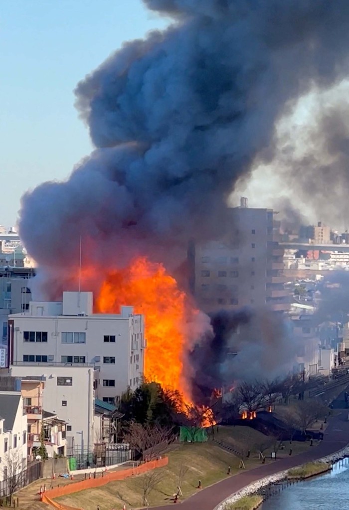 Pabrik Kimia di Tokyo Terbakar Hebat, Begini Potretnya A policeman (L) watches as smoke billows from the scene of a fire that broke out at a chemical plant warehouse in Sumida Ward in Tokyo on December 27, 2022. - Japan OUT (Photo by JIJI Press / AFP) / Japan OUT (Photo by STR/JIJI Press/AFP via Getty Images)
