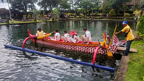 Para wisatawan saat naik perahu keliling kolam di Taman Tirta Gangga, Karangasem, Bali, Selasa (27/12/2022).