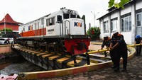 Sejumlah petugas memutar lokomotif Kereta Api (KA) seberat sekitar 80 ton dengan cara mendorong di atas sepur putar sampai mencapai posisi 180 derajat di Dipo Stasiun KA Madiun, Jawa Timur, Senin (26/12/2022).