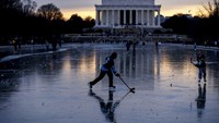Orang-orang bermain hoki es di atas kolam beku di dekat Lincoln Memorial, Washington D.C., Amerika Serikat, Senin (26/12/2022).