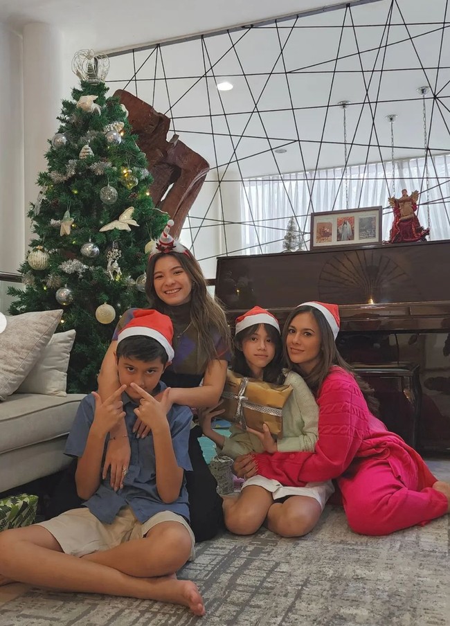 Wulan tampak berfoto bersama ketiga anaknya yang hadir untuk ikut merayakan Natal. Keempatnya terlihat kompak mengenakan hiasan kepala bertema Natal. Wulan dan kedua anaknya tampak mengenakan topi Santa Klaus, sementara Shalom mengenakan bando yang sudah dilengkapi dengan hiasan bertema Natal. Foto: Instagram/@wulanguritno