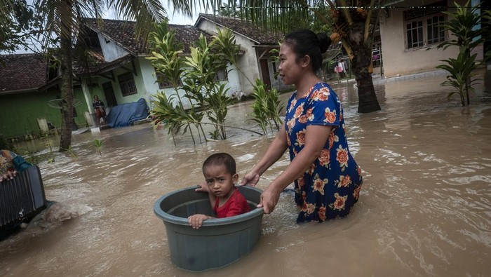 4 Kecamatan di Pandeglang Terendam Banjir Gegara Cuaca Buruk Seorang ibu membawa anaknya menggunakan ember saat melintasi banjir di Patia, Pandeglang, Banten, Selasa (27/12/2022). BPBD Kabupaten Pandeglang mencatat sebanyak 728 rumah di tiga kecamatan Pandeglang terendam banjir sejak hari Minggu (25/12/2022) dan hingga Selasa (27/12) banjir masih menggenangi kawasan tersebut. ANTARA FOTO/Muhammad Bagus Khoirunas/aww.