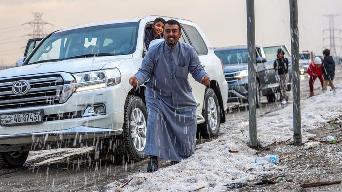 Badai Musim Dingin Melanda Kuwait, Warga Justru Kegirangan Main Salju People inspect hail particles lying on the side of a road after a storm in the Umm al-Haiman district, about 55 kilometres south of Kuwait City, on December 27, 2022. (Photo by YASSER AL-ZAYYAT / AFP) (Photo by YASSER AL-ZAYYAT/AFP via Getty Images)