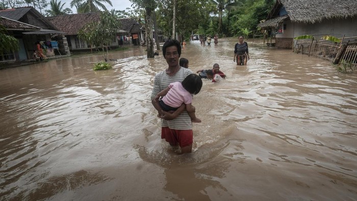 BANJIR AKIBAT CUACA EKSTREM DI PANDEGLANG Warga berjalan melintasi banjir di Patia, Pandeglang, Banten, Selasa (27/12/2022). BPBD Kabupaten Pandeglang mencatat sebanyak 728 rumah di tiga kecamatan Pandeglang terendam banjir sejak hari Minggu (25/12/2022) dan hingga Selasa (27/12) banjir masih menggenangi kawasan tersebut. ANTARA FOTO/Muhammad Bagus Khoirunas/aww.