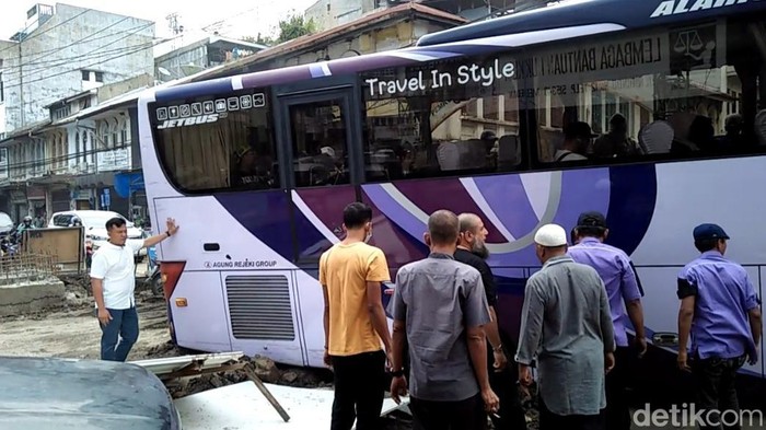 Bus Pariwisata terperosok ke lubang jalan yang sedang diperbaiki di Jalan Hindu, Kecamatan Medan Baru, Kota Medan. Bus itu membawa puluhan wisatawan dari Malaysia. (Goklas/detikSumut)