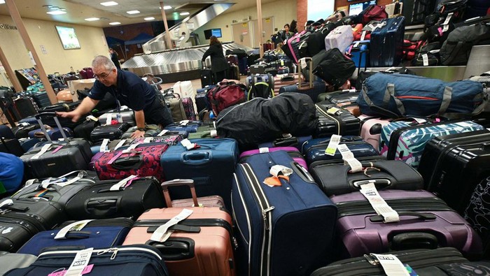 A Southwest Airlines employee sorts through unclaimed luggage at Hollywood Burbank Airport in Burbank, California, on December 27, 2022. - More than 10,000 flights cancelled over the Christmas holiday, chaos at airports across America: Southwest Airlines found itself in the hot seat on December 27, 2022, as the airline behind the lion's share of the weather-linked travel mayhem. (Photo by Robyn BECK / AFP) (Photo by ROBYN BECK/AFP via Getty Images)