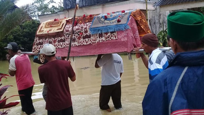Banjir melanda Kecamatan Sobang, Pandeglang, Banten, berdampak kepada proses pemakaman salah satu warga yang meninggal. Warga harus menggotong jenazah menembus banjir menuju tempat pemakaman umum (TPU).