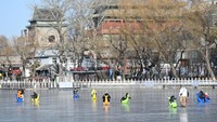 Orang-orang berseluncur di Danau Sincha yang membeku di Beijing, China, Selasa (27/12/2022).