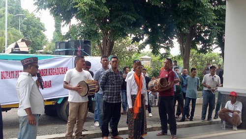 Aksi warga menabung gendang dan gong di depan Kantor DPRD Manggarai Barat, Rabu (28/12/2022).