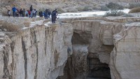 Warga Israel menyaksikan banjir bandang yang terjadi menyusul hujan lebat di gurun Negev di sebelah timur kota Dimona, Israel, Senin (26/12/2022).  