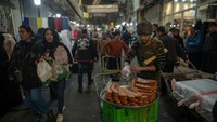 Warga masih beraktivitas seperti biasa di tengah kenaikan harga-harga barang. Foto: Getty Images/Majid Saeedi