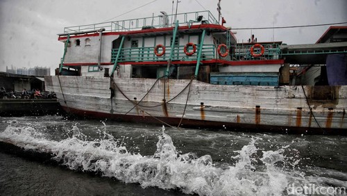 Nelayan Melintasi banjir rob saat cuaca buruk di Pelabuhan Muara Baru, Penjaringan, Jakarta Utara, Rabu (28/12/2022).