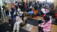 Pengunjung memenuhi area Changing Area, yaitu tempat para pengunjung mengganti alas kaki yang mereka kenakan untuk diganti menjadi sepatu khusus untuk di salju.