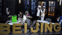 Warga berswafoto di luar toko roti populer di Beijing, Rabu (28/12/2022). China mengatakan akan melanjutkan penerbitan paspor untuk pariwisata sebagai langkah besar menjauh dari kontrol anti-virus yang mengisolasi negara itu selama hampir tiga tahun. AP/Ng Han Guan