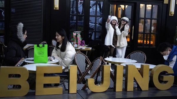 Warga berswafoto di luar toko roti populer di Beijing, Rabu (28/12/2022). China mengatakan akan melanjutkan penerbitan paspor untuk pariwisata sebagai langkah besar menjauh dari kontrol anti-virus yang mengisolasi negara itu selama hampir tiga tahun. AP/Ng Han Guan Warga berswafoto di luar toko roti populer di Beijing, Rabu (28/12/2022). China mengatakan akan melanjutkan penerbitan paspor untuk pariwisata sebagai langkah besar menjauh dari kontrol anti-virus yang mengisolasi negara itu selama hampir tiga tahun. AP/Ng Han Guan