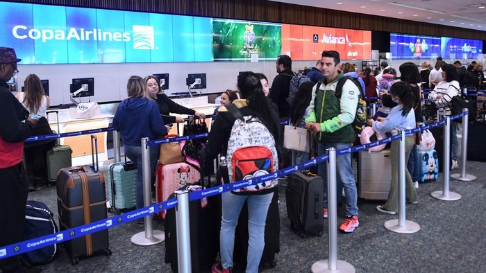 Badai Salju Hantam AS, Penerbangan Banyak yang Batal ORLANDO, FLORIDA, UNITED STATES - DECEMBER 28: Travelers wait in line to check in for their flights at a Copa Airlines ticket ticket counter at Orlando International Airport during the busy Christmas holiday season on December 28, 2022 in Orlando, Florida. The holiday travel period has been plagued by a winter storm and thousands of delayed and cancelled flights, the majority of which have occurred at Southwest Airlines. (Photo by Paul Hennessy/Anadolu Agency via Getty Images)
