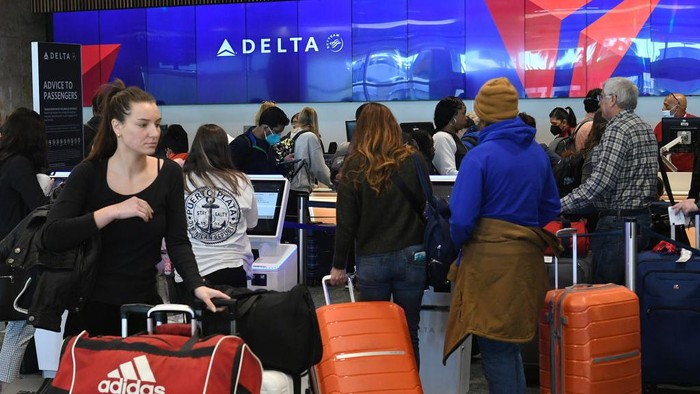 Badai Salju Hantam AS, Penerbangan Banyak yang Batal ORLANDO, FLORIDA, UNITED STATES - DECEMBER 28: Travelers wait in line to check in for their flights at a Delta Airlines ticket ticket counter at Orlando International Airport during the busy Christmas holiday season on December 28, 2022 in Orlando, Florida. The holiday travel period has been plagued by a winter storm and thousands of delayed and cancelled flights, the majority of which have occurred at Southwest Airlines. (Photo by Paul Hennessy/Anadolu Agency via Getty Images)