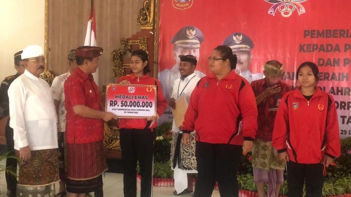Bupati Karangasem I Gede Dana saat memberikan bonus kepada para atlet peraih medali saat Porprov 2022 Bali. (Foto: I Wayan Selamat Juniasa/detikBali)