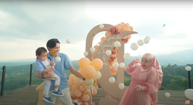 Dinda pun meledakkan balon hitam yang tadi dipegangnya. Ketika balon diledakkan justru yang muncul ialah balon berwarna putih dan coklat keoranyean. Foto: YouTube/Rein TV