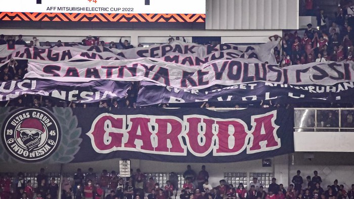 Dorong Kemajuan Sepakbola, Supporter Minta PSSI Revolusi Seorang suporter Timnas Indonesia membentangkan poster saat pertandingan sepak bola Grup A Piala AFF 2022 melawan Thailand di Stadion Utama Gelora Bung Karno (SUGBK), Jakarta, Kamis (29/12/2022). Aksi tersebut terkait tuntutan agar pemerintah mengusut tuntas tragedi Kanjuruhan yang menelan korban 135 orang meninggal dan ratusan lainnya luka-luka.