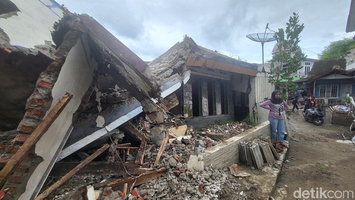 Enung di depan rumahnya yang hancur akibat pergeseran tanah di Nyalindung Sukabumi