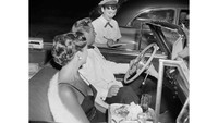 Potret drive-thru ini lebih mewah dimana pelanggan disambangi langsung oleh pegawai restoran ke mobil. Foto ini diambil tahun 1951 di Tiny Naylors Drive-In Restaurant, Los Angeles.