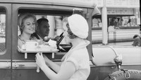 Foto ini diambil tahun 1932 di gerai Carpenters Sandwiches, Amerika Serikat. Tampak pegawai mengantarkan menu pesanan pengunjung ke mobil.