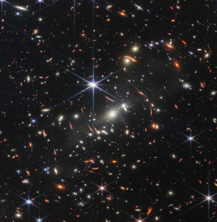 This image is dominated by NGC 7469, a luminous, face-on spiral galaxy approximately 90 000 light-years in diameter that lies roughly 220 million light-years from Earth in the constellation Pegasus. Its companion galaxy IC 5283 is partly visible in the lower left portion of this image. This spiral galaxy has recently been studied as part of the Great Observatories All-sky LIRGs Survey (GOALS) Early Release Science program with the NASA/ESA/CSA James Webb Space Telescope, which aims to study the physics of star formation, black hole growth, and feedback in four nearby, merging luminous infrared galaxies. Other galaxies studied as part of the survey include previous ESA/Webb Pictures of the Month II ZW 096 and IC 1623. NGC 7469 is home to an active galactic nucleus (AGN), which is an extremely bright central region that is dominated by the light emitted by dust and gas as it falls into the galaxys central black hole. This galaxy provides astronomers with the unique opportunity to study the relationship between AGNs and starburst activity because this particular object hosts an AGN that is surrounded by a starburst ring at a distance of a mere 1500 light-years. While NGC 7469 is one of the best studied AGNs in the sky, the compact nature of this system and the presence of a great deal of dust have made it difficult for scientists to achieve both the resolution and sensitivity needed to study this relationship in the infrared. Now, with Webb, astronomers can explore the galaxys starburst ring, the central AGN, and the gas and dust in between. Using Webbs MIRI, NIRCam and NIRspec instruments to obtain images and spectra of NGC 7469 in unprecedented detail, the GOALS team has uncovered a number of details about the object. This includes very young star-forming clusters never seen before, as well as pockets of very warm, turbulent molecular gas, and direct evidence for the destruction of small dust grains within a few hundred light-years of the nucleus  proving