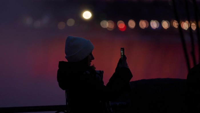 Tourists takes a selfie at the Horseshoe Falls in Niagara Falls, Ontario, on December 28, 2022. - Niagara Falls only saw a small amount of snow during the winter storm which hit the region late last week but Buffalo, only 40km away received an epic blast of lake effect snow. (Photo by Geoff Robins / AFP) (Photo by GEOFF ROBINS/AFP via Getty Images)