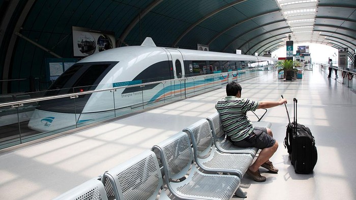 Passengers wait to board the Transrapid magnetic levitation (maglev) train at its station in Shanghai, China on 20 June 2009. A often criticized grand infrastructure pet project of the Shanghai government, the Shanghai maglev line is the only operational commercial one in the world, reaching speeds of up to 430KPH during its 33 kilometer journey connecting the City's Pudong Airport with the Longyang Road subway station on the edge of the city. (Photo by In Pictures Ltd./Corbis via Getty Images)