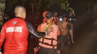 Petugas menggendong warga korban banjir.
