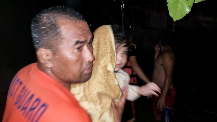 Korban Banjir Filipina Terus Dievakuasi A rescue worker holds a child while helping people affected by floods, in Plaridel, Misamis Occidental Province, Philippines, December 26, 2022. Philippine Coast Guard/Handout via REUTERS THIS IMAGE HAS BEEN SUPPLIED BY A THIRD PARTY. MANDATORY CREDIT. NO RESALES. NO ARCHIVES