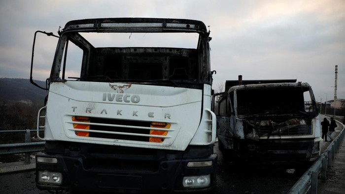 Burned trucks block a road in the ethnically divided town of Mitrovica, Kosovo December 29, 2022. REUTERS/Florion Goga