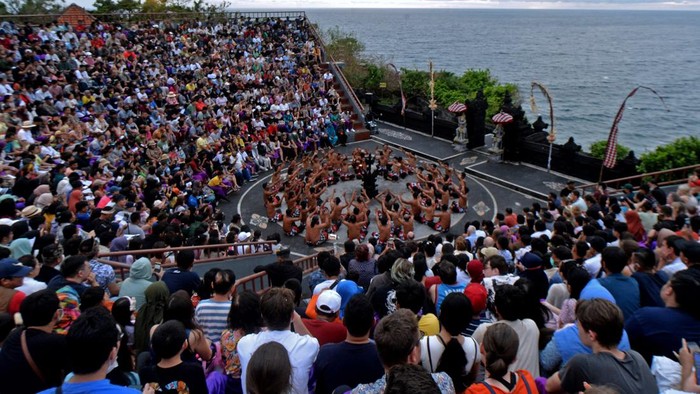 Penari berinteraksi dengan wisatawan yang menyaksikan atraksi wisata Tari Kecak Uluwatu di kawasan Uluwatu, Badung, Bali, Rabu (28/12/2022). Tari Kecak Uluwatu yang dipentaskan dalam dua sesi setiap harinya itu menjadi salah satu atraksi wisata yang ramai dikunjungi wisatawan liburan akhir tahun di Pulau Dewata.